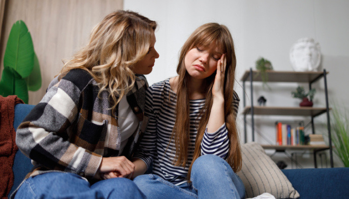 Worried mature mother comforts her daughter, helping with problem and depression